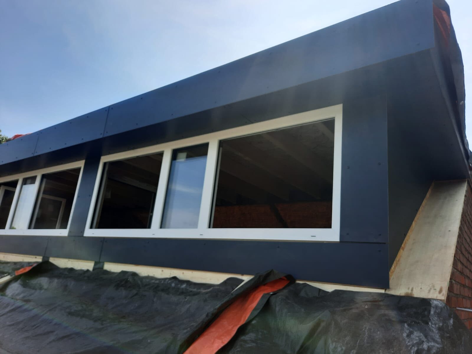 Nieuwe dakkapel met antraciet trespa en witte kozijnen door Klus Expert Breda