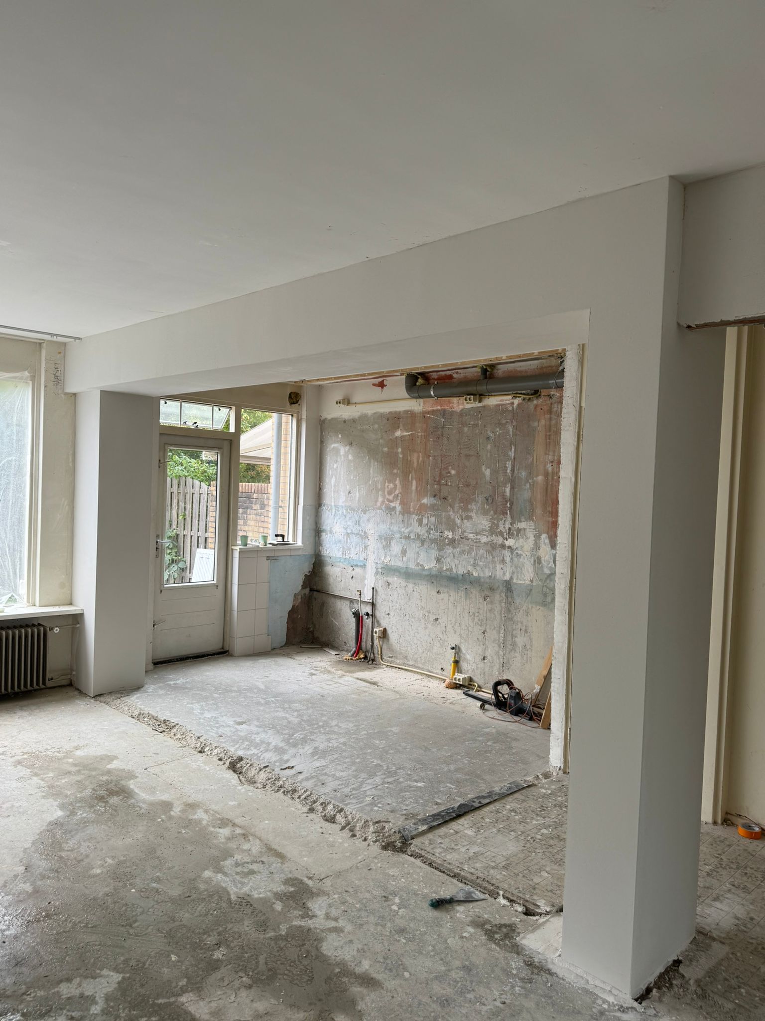 Afgewerkte doorbraak met strak gestucte constructiebalk en kolom