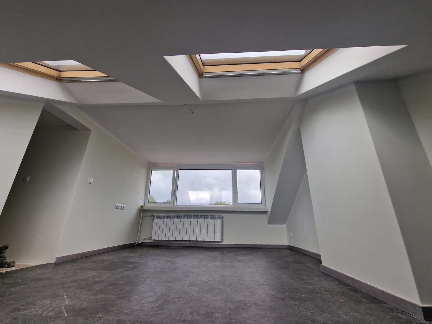 afgewerkte zolderkamer met dakraam